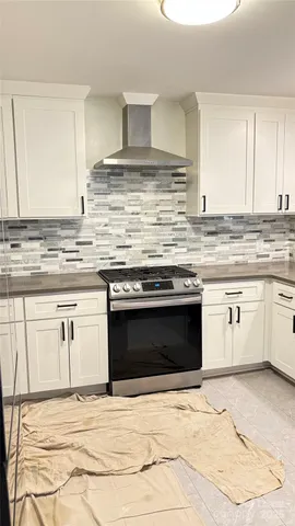 a kitchen with granite countertop a stove top oven sink and cabinets