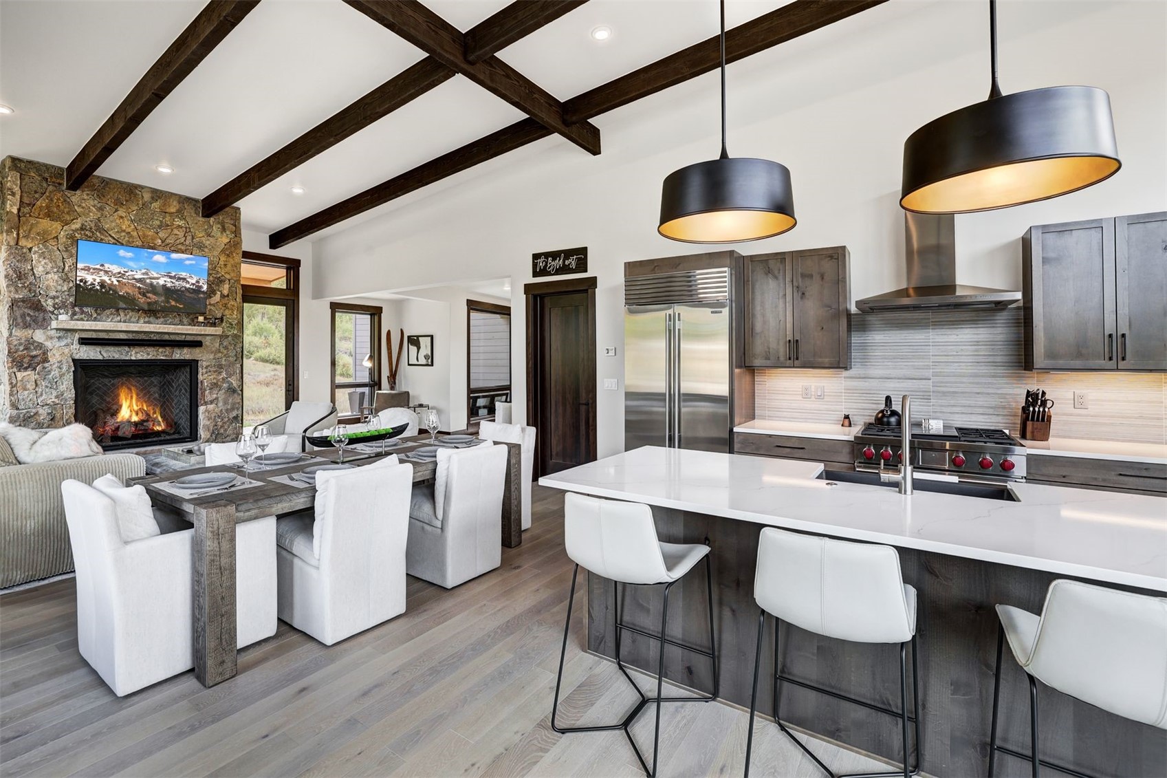 160 Vendette Road Silverthorne, CO 80498 - Photo 50 of 50 Kitchen with beam ceiling, open floor plan, a breakfast bar, built in fridge, and a stone fireplace