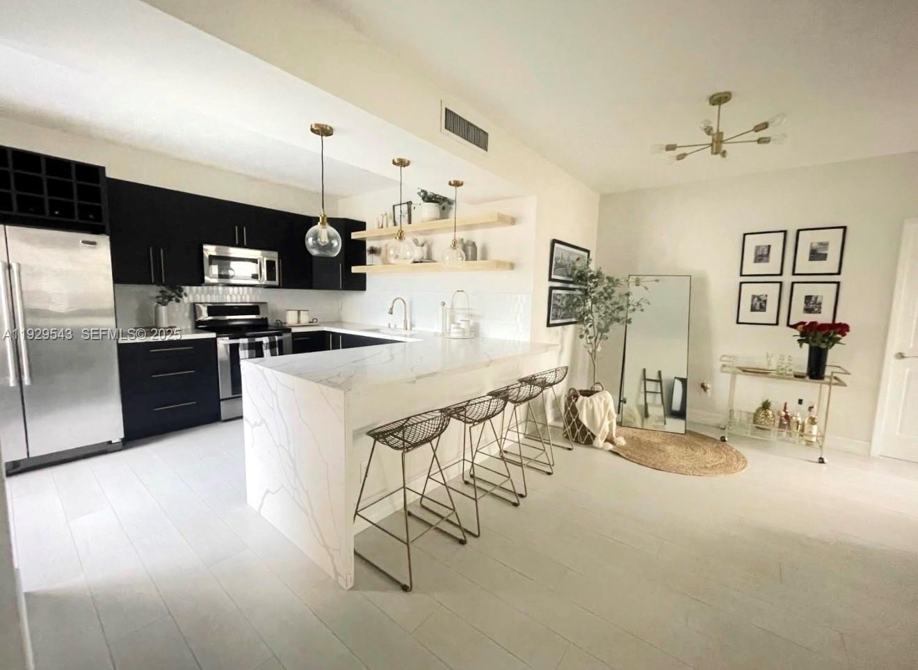 11864 Northwest 11th Street, Unit 11864 Pembroke Pines, FL 33026 - Photo 1 of 13 a kitchen with stainless steel appliances kitchen island granite countertop a sink and cabinets