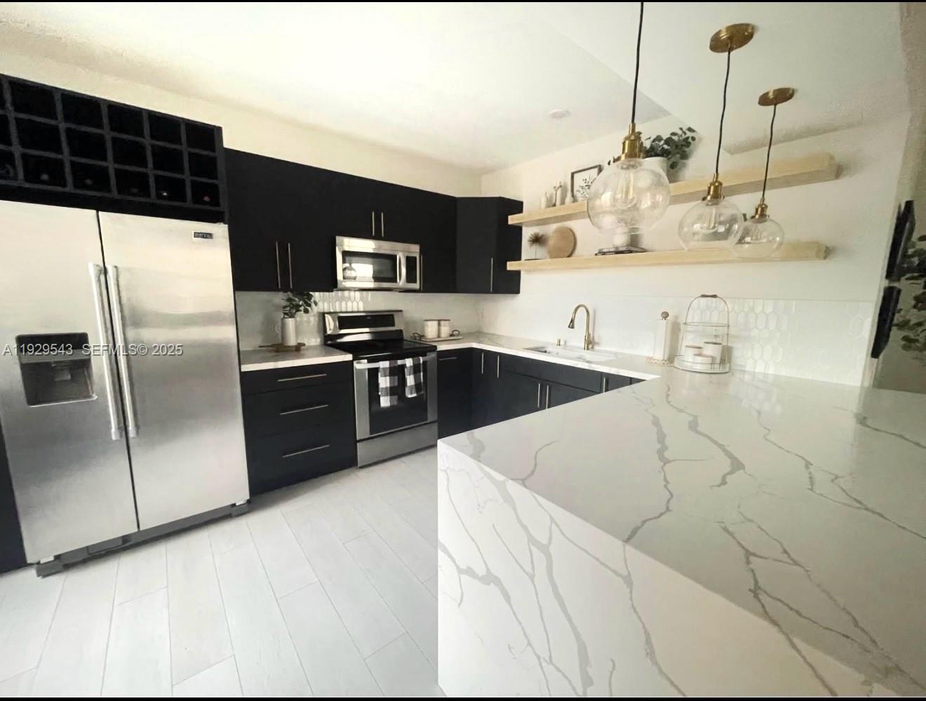 11864 Northwest 11th Street, Unit 11864 Pembroke Pines, FL 33026 - Photo 2 of 13 a kitchen with stainless steel appliances granite countertop a sink a stove and a refrigerator