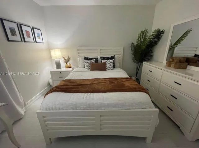a bedroom with a bed and a potted plant