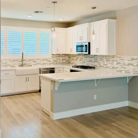 a kitchen with stainless steel appliances granite countertop a stove a sink and a microwave