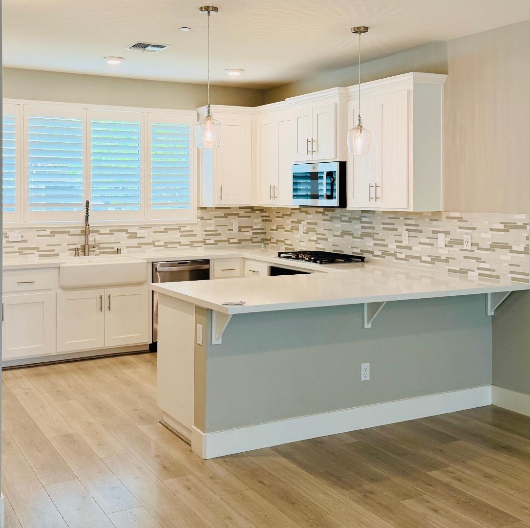 1946 Pollock Way Lodi, CA 95242 - Photo 8 of 35 a kitchen with stainless steel appliances granite countertop a stove a sink and a microwave