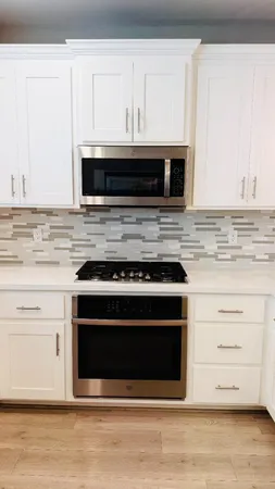 a kitchen with granite countertop a stove microwave and cabinets