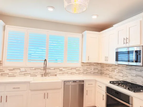 a kitchen with stainless steel appliances granite countertop a sink and a stove
