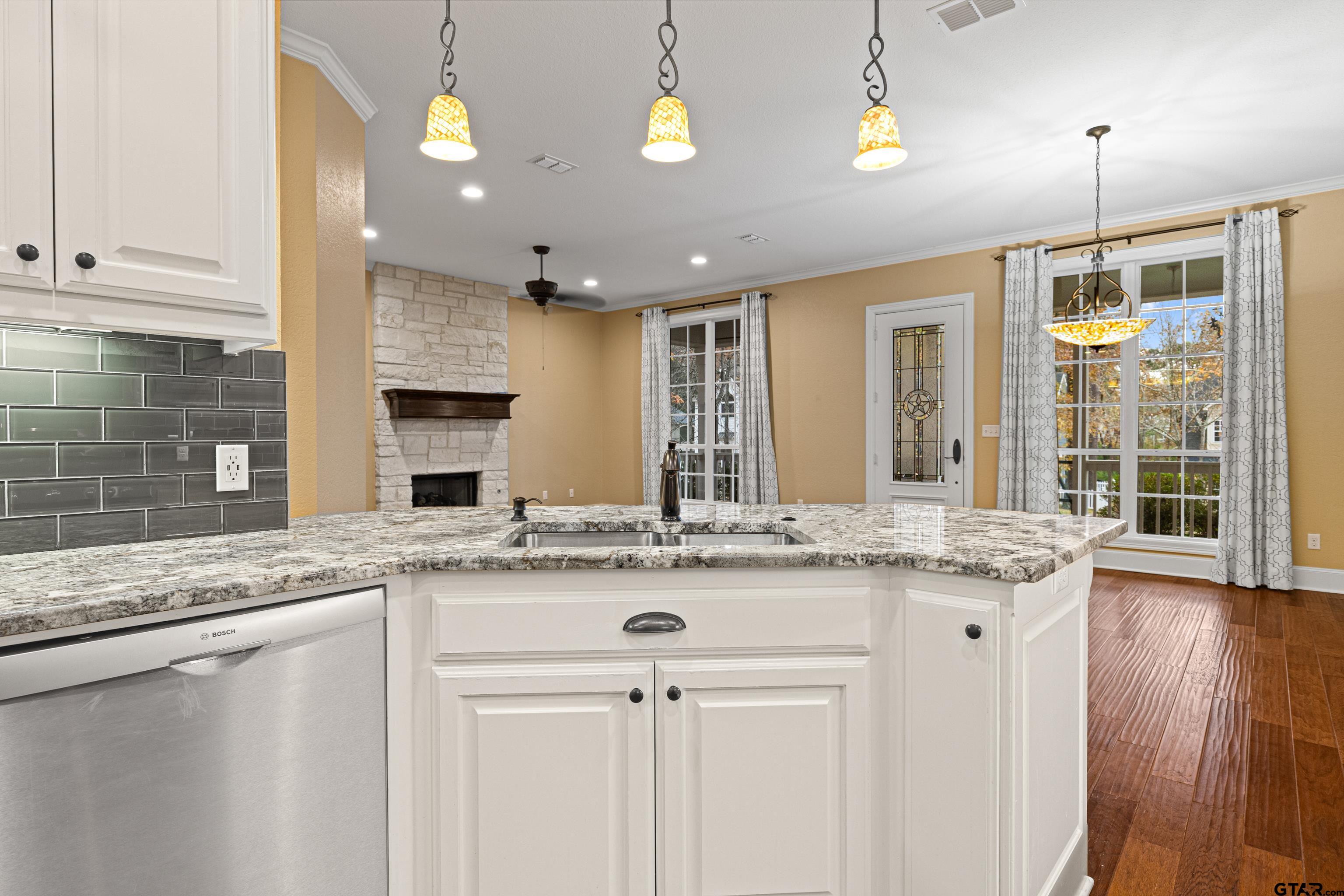 3949 Hanover Place Tyler, TX 75701 - Photo 15 of 43 a kitchen with stainless steel appliances granite countertop a sink a oven a dining table and chairs with wooden floor