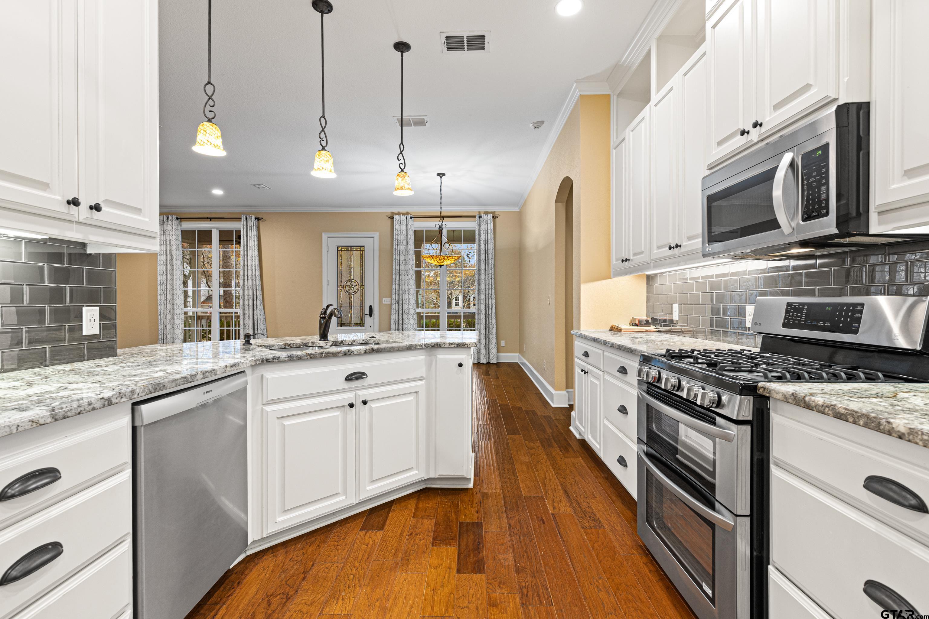 3949 Hanover Place Tyler, TX 75701 - Photo 16 of 43 a large kitchen with stainless steel appliances granite countertop a stove a sink and a microwave