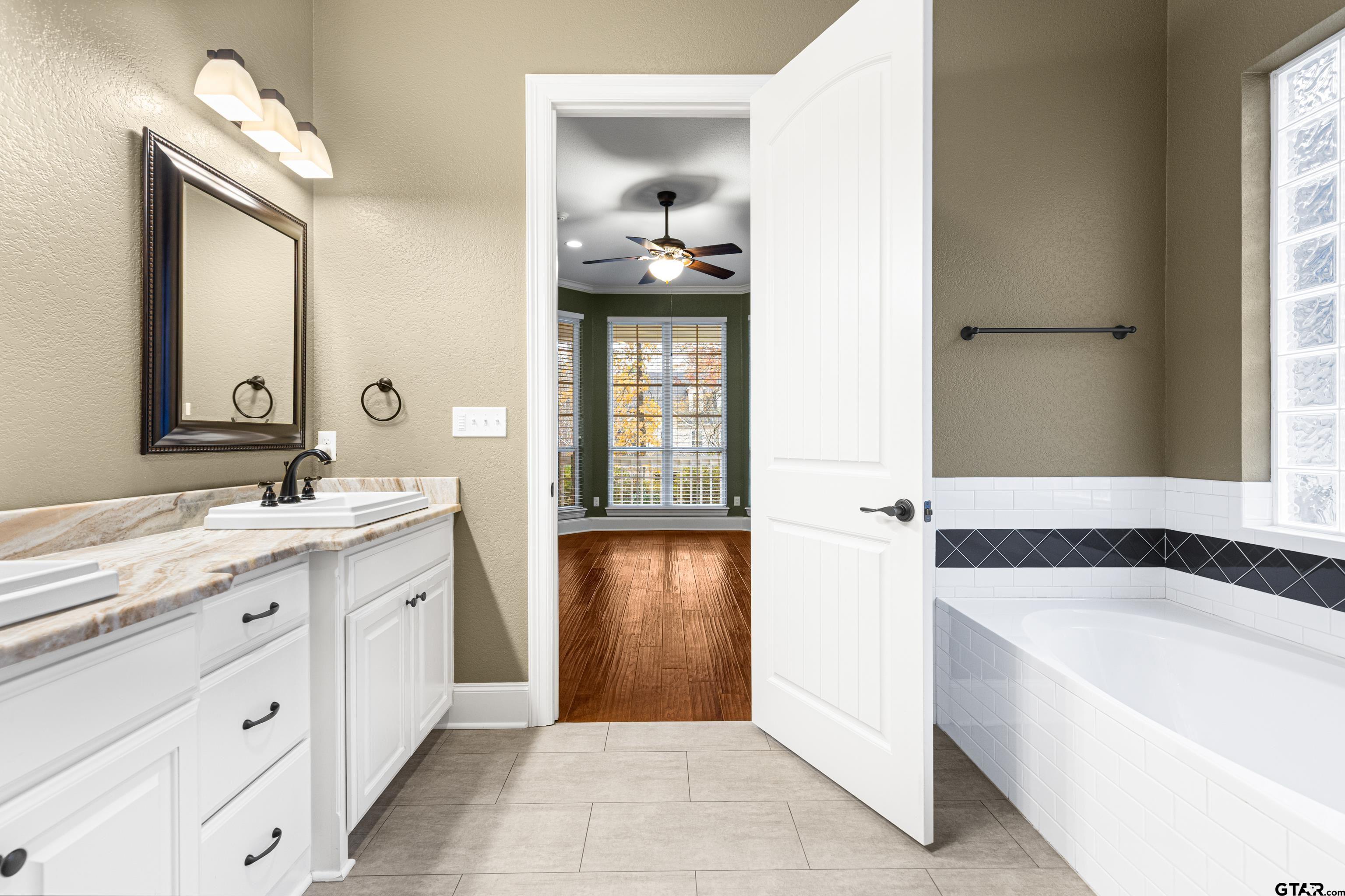 3949 Hanover Place Tyler, TX 75701 - Photo 26 of 43 a bathroom with a tub sink and mirror