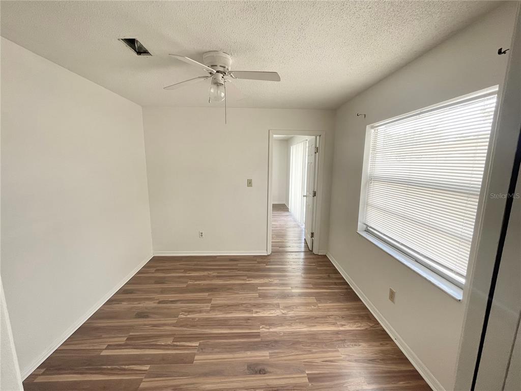 5912 Altec Road Orlando, FL 32808 - Photo 14 of 33 a view of an empty room with wooden floor and window