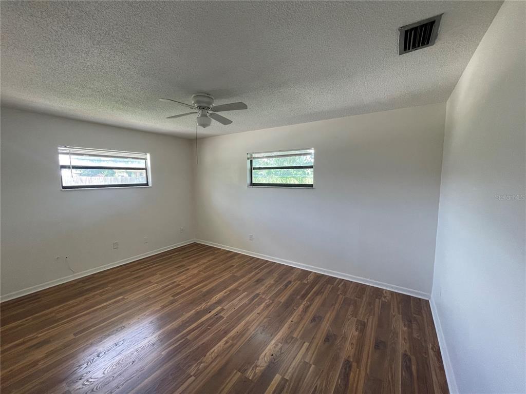 5912 Altec Road Orlando, FL 32808 - Photo 26 of 33 a view of an empty room with wooden floor and a window