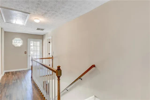 a view of a hallway with wooden floor and entryway