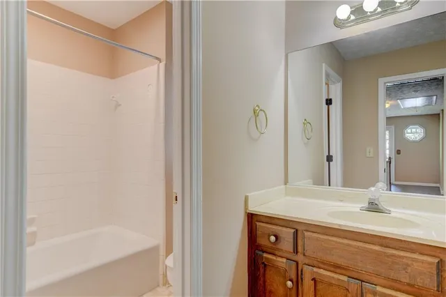 a bathroom with a granite countertop sink a mirror and a bathtub