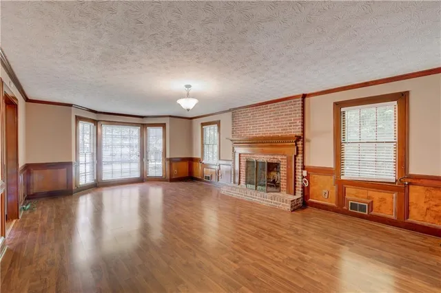 a view of a livingroom with wooden floor and a fireplace