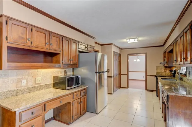 a kitchen with stainless steel appliances granite countertop a refrigerator and a sink