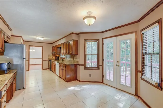 a large kitchen with stainless steel appliances granite countertop a large window and a counter top space