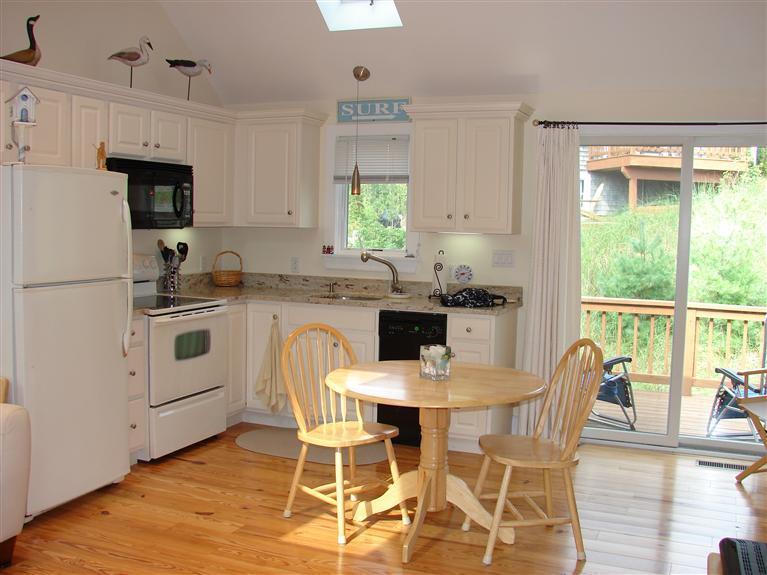 6 Shore Road, Unit 9 Truro, MA 02666 - Photo 1 of 19 a kitchen with stainless steel appliances a white table and chairs in it