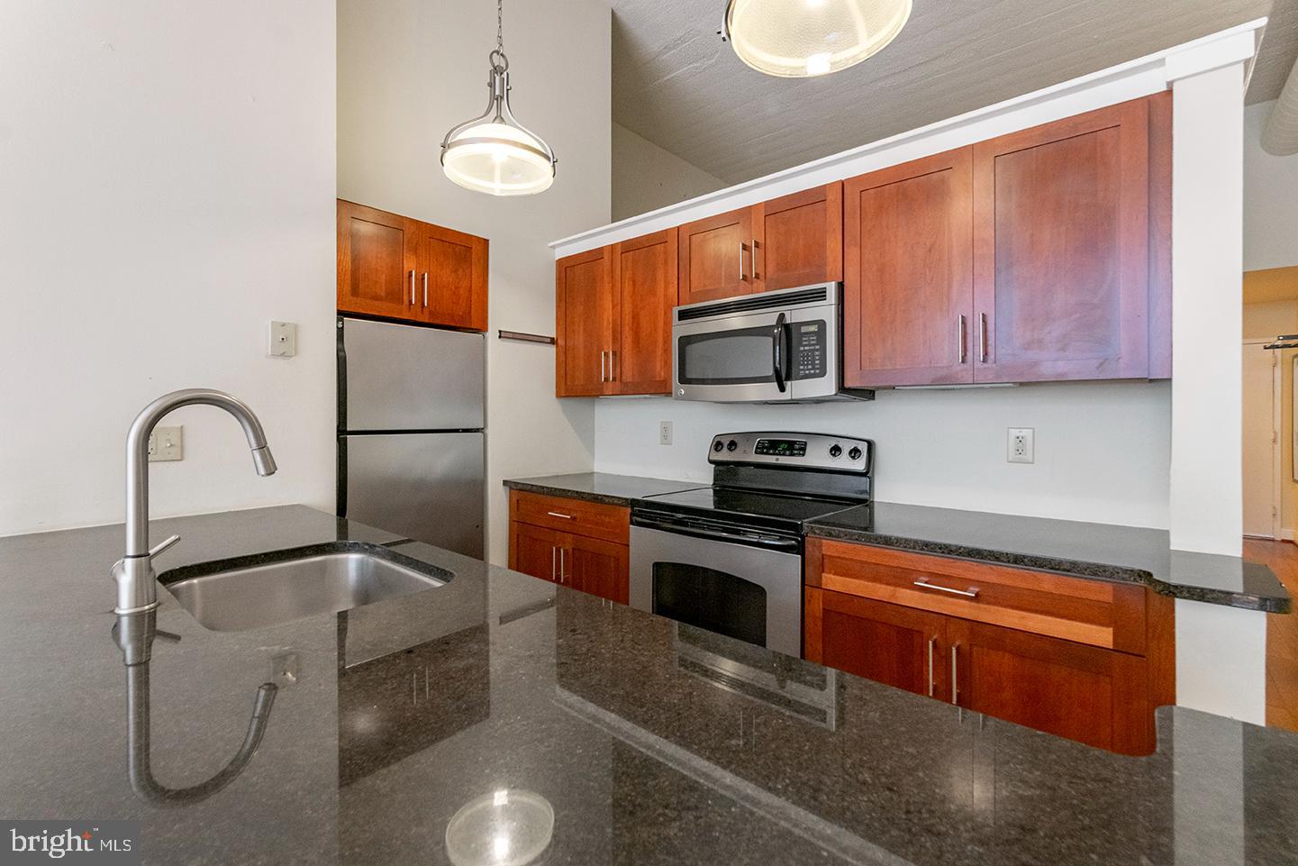 2429 Locust Street, Unit 513 Philadelphia, PA 19103 - Photo 2 of 11 a kitchen with stainless steel appliances granite countertop a sink microwave and stove top oven