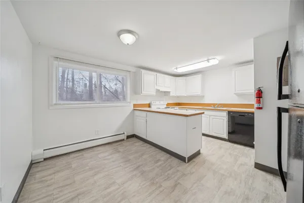 a kitchen with stainless steel appliances a sink a stove a refrigerator and cabinets