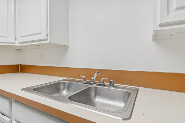 a kitchen with white cabinets and white appliances