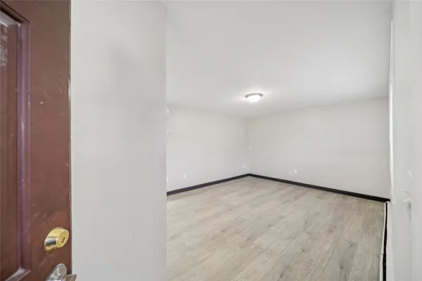 a view of a room with wooden floor and window