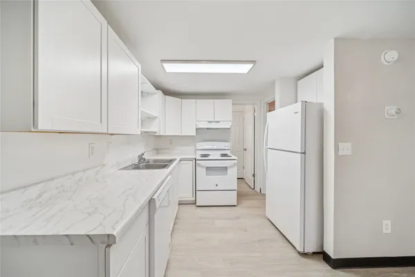a kitchen with cabinets appliances a sink and a counter top