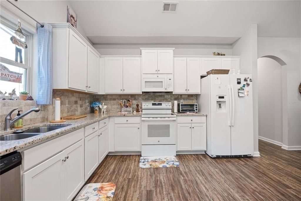 413 River Bluff Drive Temple, GA 30179 - Photo 15 of 30 a kitchen with white cabinets and white appliances