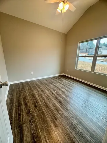a view of a backyard with potted plants and large trees
