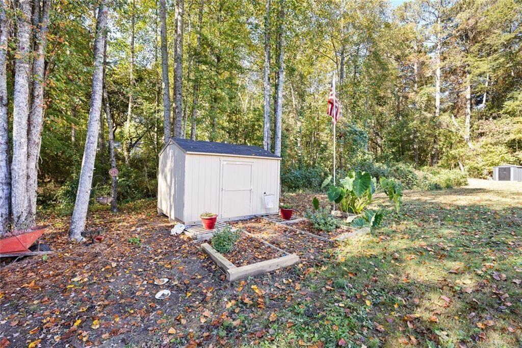 413 River Bluff Drive Temple, GA 30179 - Photo 27 of 30 a view of a backyard with potted plants and large trees