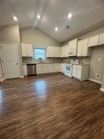 a view of kitchen with stainless steel appliances granite countertop a stove and a sink