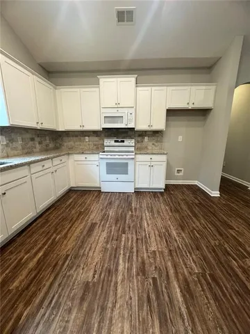 an empty room with wooden floor and mirror