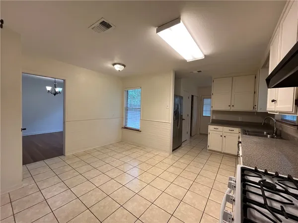 a kitchen with a refrigerator and white cabinets
