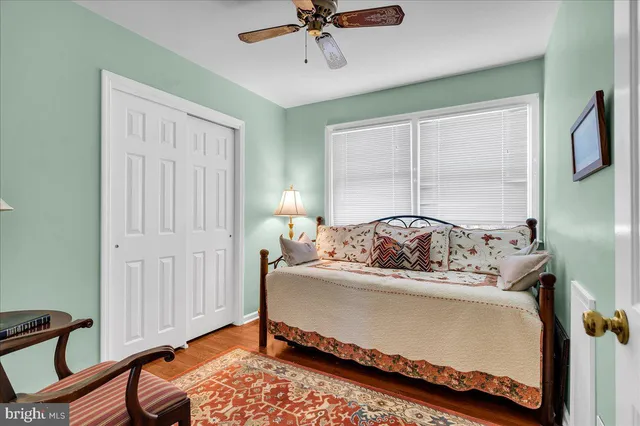 a bedroom with a bed a table and chair with window