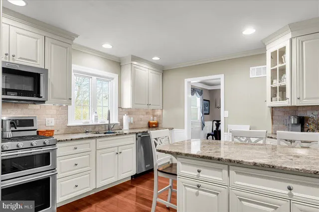 a kitchen with stainless steel appliances granite countertop a refrigerator sink and stove