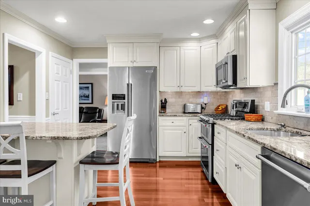 a kitchen with stainless steel appliances granite countertop a stove and a refrigerator