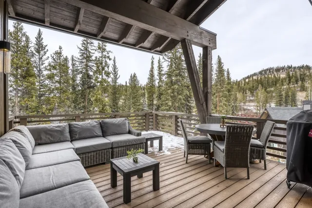 a roof deck with couches and wooden floor