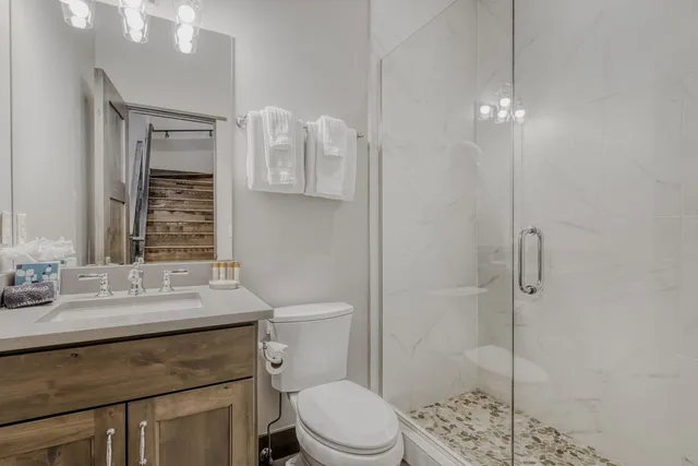 a bathroom with a sink a toilet and shower