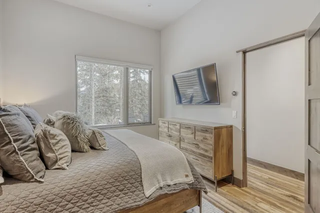 a bedroom with a bed and wooden floor