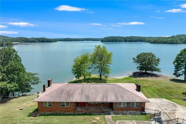 a aerial view of a house with swimming pool garden and lake view