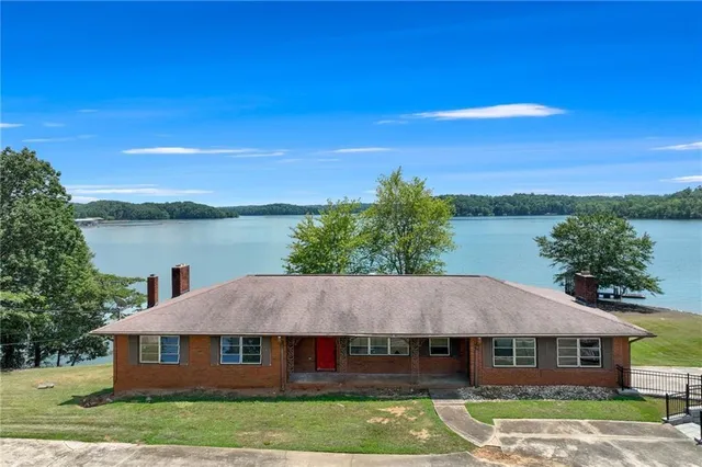 a aerial view of a house next to a yard with a lake view