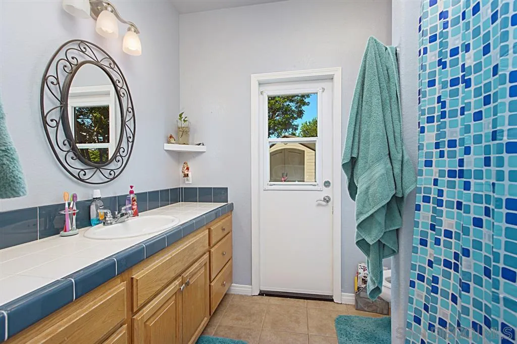 1400 Eucalyptus Drive El Cajon, CA 92021 - Photo 12 of 23 a bathroom with a granite countertop sink and a mirror