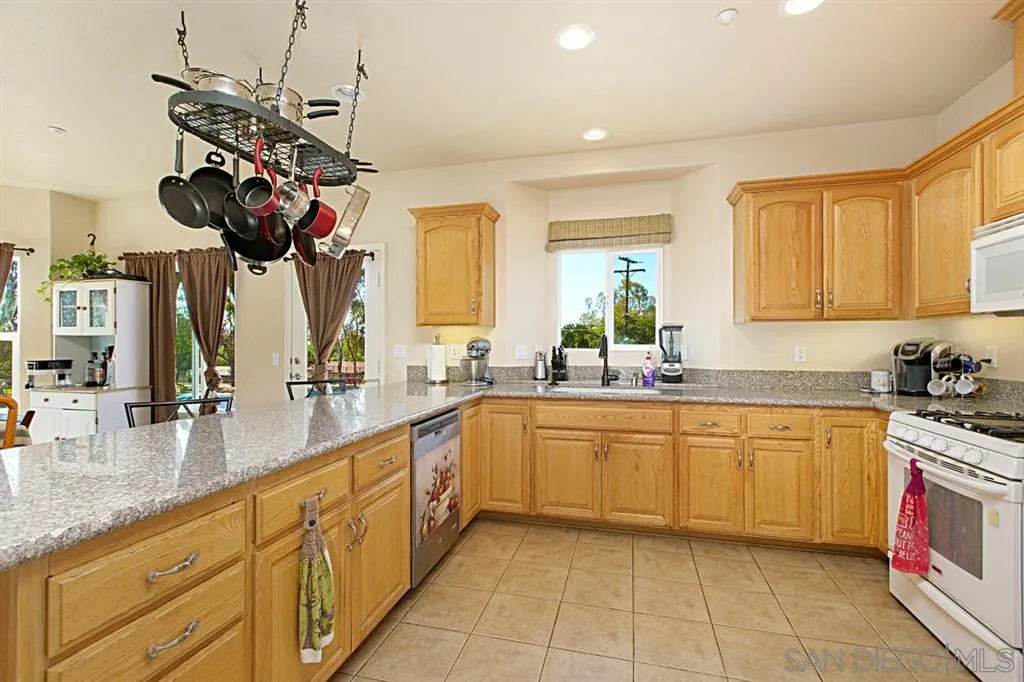 1400 Eucalyptus Drive El Cajon, CA 92021 - Photo 5 of 23 a kitchen with stainless steel appliances granite countertop a sink a stove and a wooden floors