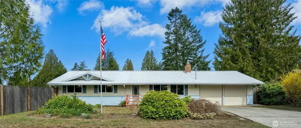 a front view of a house with a yard and trees