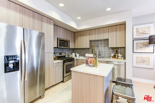 a kitchen with a refrigerator a sink dishwasher and a stove with wooden floor