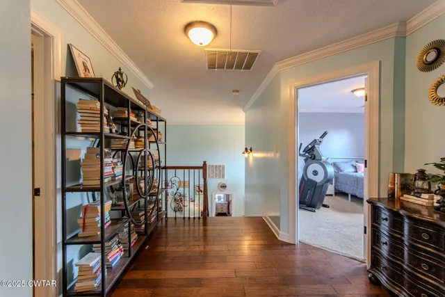 a view of a hallway with wooden floor and stairs