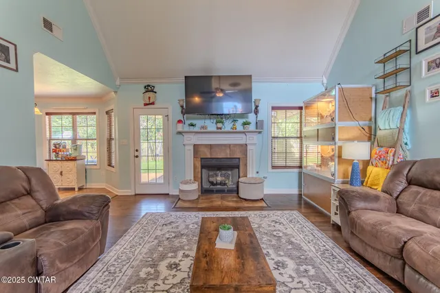 a living room with furniture a flat screen tv and a fireplace