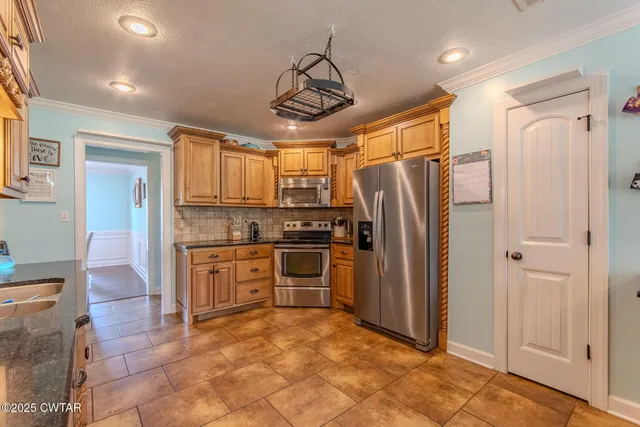 a kitchen with stainless steel appliances granite countertop a refrigerator and a stove top oven