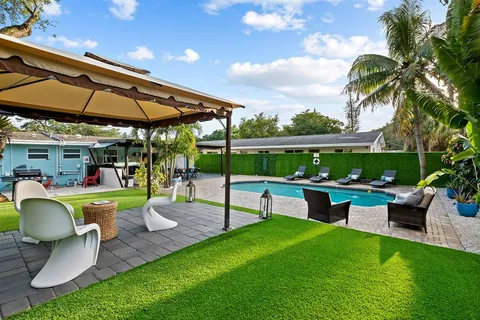 a view of a swimming pool with lawn chairs under an umbrella