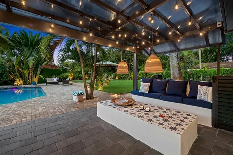a view of a patio with couches table and chairs with wooden floor and fence