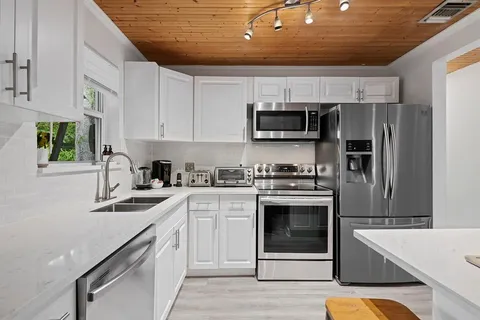 a kitchen with white cabinets and white appliances