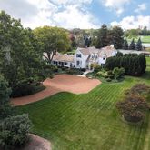 an aerial view of residential houses with outdoor space and trees
